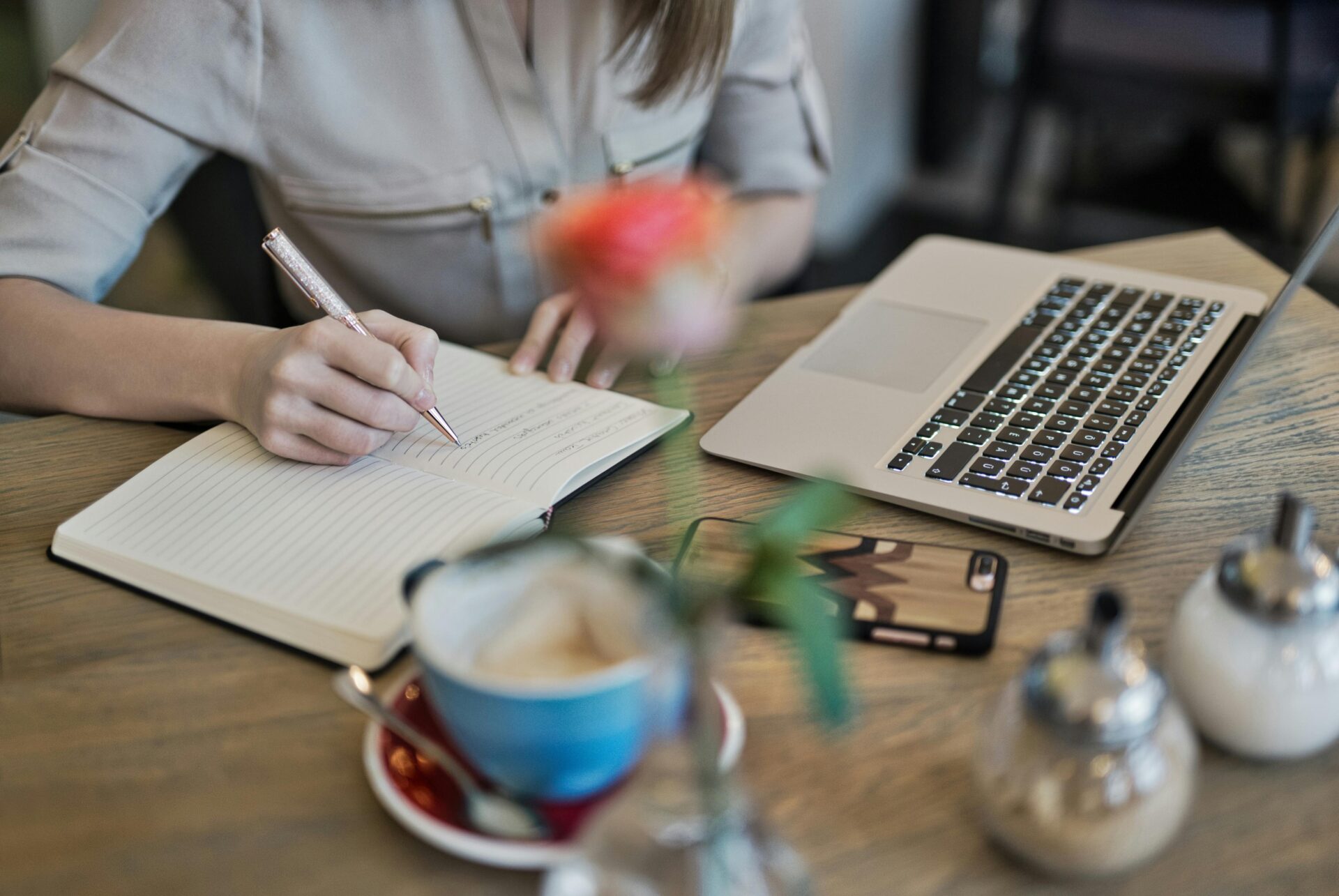 a woman journaling by her computer